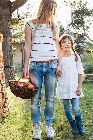 Mother and daughter holding hands, mother holding basket of apples Stock Photo - Premium Royalty-Free, Code: 649-08479531