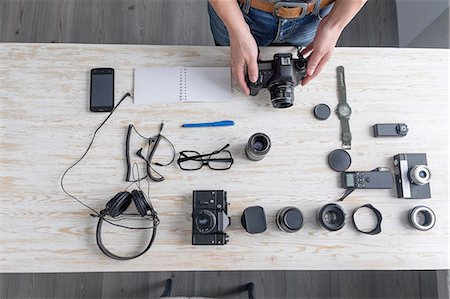 Overhead view of male photographer preparing camera on studio desk Stock Photo - Premium Royalty-Free, Code: 649-08479755