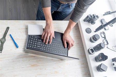 photographer - Overhead view of male photographer typing on studio desk laptop Stock Photo - Premium Royalty-Free, Code: 649-08479756