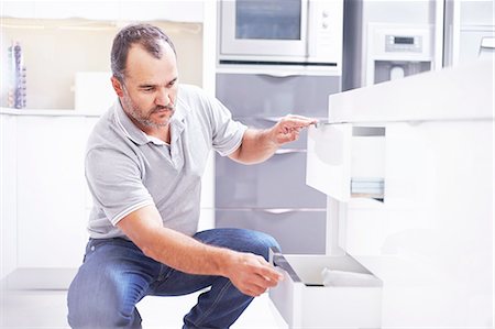 picture of mature in kitchen - Joiner installing drawers in kitchen Photographie de stock - Premium Libres de Droits, Code: 649-08479819