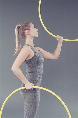 Young woman practising with hula hoop, grey background Stockbilder - Premium RF Lizenzfrei, Bildnummer: 649-08479905