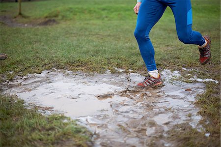 Legs of runner running through muddy puddle Photographie de stock - Premium Libres de Droits, Code: 649-08479961