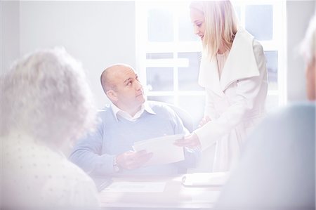 financial planning - Secretary handing paperwork to businessman in office Stock Photo - Premium Royalty-Free, Code: 649-08479970