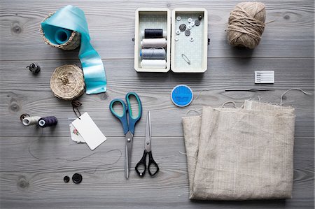 Overhead view of sewing equipment with textiles, threads and scissors Photographie de stock - Premium Libres de Droits, Code: 649-08480045