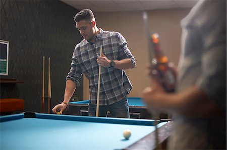 Man preparing to play pool, friend with beer in foreground Stock Photo - Premium Royalty-Free, Code: 649-08480206