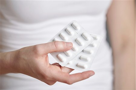 simsearch:649-08480341,k - Cropped close up of young woman holding two medicine blister packs Foto de stock - Sin royalties Premium, Código: 649-08480342