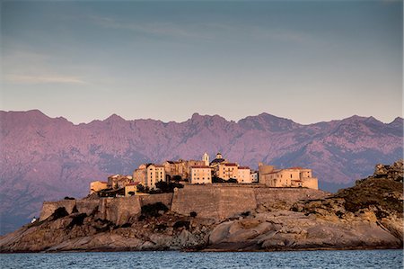 View of sea and Calvi on headland at dusk, Corsica, France Stock Photo - Premium Royalty-Free, Code: 649-08480367