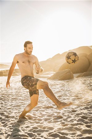 simsearch:6122-07694575,k - Mid adult man wearing swimming shorts playing soccer on beach, Cape Town, South Africa Stock Photo - Premium Royalty-Free, Code: 649-08544025