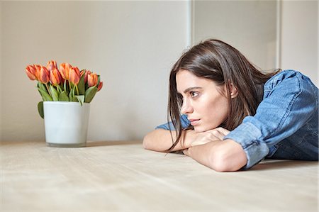 Young woman leaning forward on dining table Foto de stock - Sin royalties Premium, Código: 649-08544066