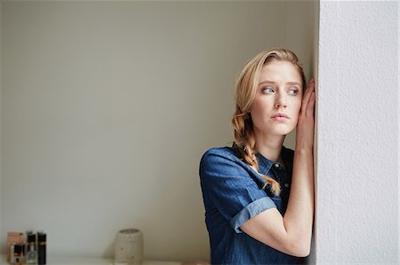 simsearch:649-08543187,k - Beautiful young woman with blond plait leaning against door Stock Photo - Premium Royalty-Free, Code: 649-08544119