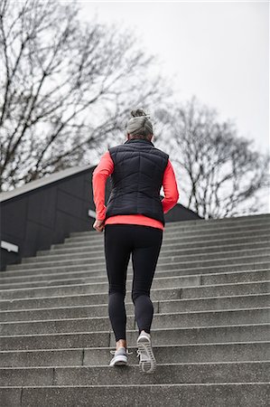 Rear view of mature female runner running up city stairway Stock Photo - Premium Royalty-Free, Code: 649-08544125