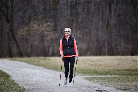 simsearch:649-07710283,k - Mature female training in park, nordic walking with poles Photographie de stock - Premium Libres de Droits, Code: 649-08544132