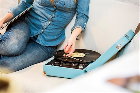 simsearch:649-08544187,k - Cropped shot of young woman sitting on sofa listening to vintage record player Foto de stock - Sin royalties Premium, Código: 649-08544185