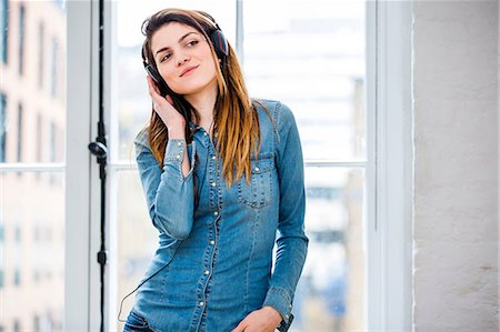 simsearch:649-08544187,k - Beautiful young woman listening to music in front of city apartment window Foto de stock - Sin royalties Premium, Código: 649-08544182