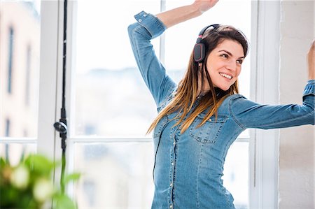 simsearch:649-08544187,k - Young woman dancing in front of city apartment window Foto de stock - Sin royalties Premium, Código: 649-08544183