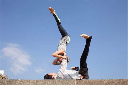 simsearch:614-09127241,k - Man and woman practicing acrobatic yoga against blue sky Foto de stock - Sin royalties Premium, Código: 649-08544226