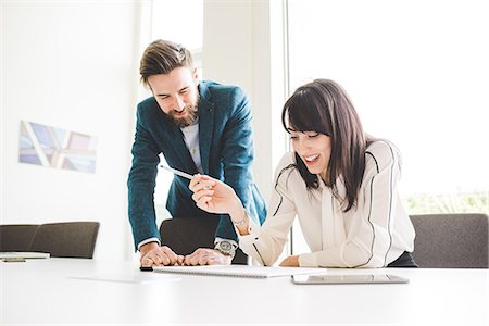 simsearch:649-08577545,k - Young businessman and woman writing on notepad at conference table Fotografie stock - Premium Royalty-Free, Codice: 649-08544248