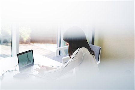 simsearch:649-08577545,k - Window view of businesswoman using laptop at office desk Fotografie stock - Premium Royalty-Free, Codice: 649-08544242