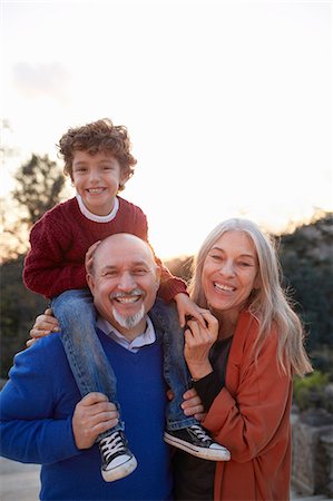 Grandparents with grandson on shoulders looking at camera smiling Stock Photo - Premium Royalty-Free, Code: 649-08544345