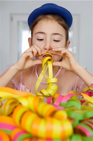 people spiral - Girl wearing blue hat looking down blowing party streamers Stock Photo - Premium Royalty-Free, Code: 649-08548055