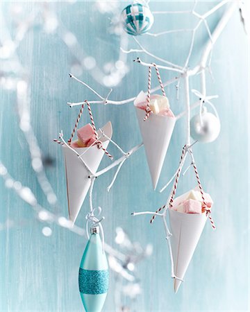 Coconut ice in paper cones hanging from painted white branch Stock Photo - Premium Royalty-Free, Code: 649-08548247