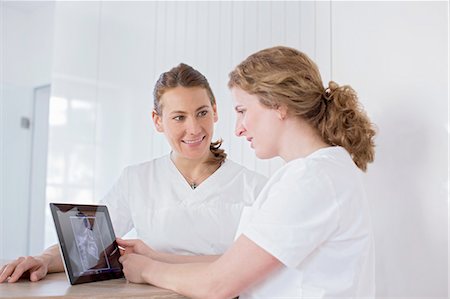 Dentists looking at digital tablet with x-ray image on screen, smiling Photographie de stock - Premium Libres de Droits, Code: 649-08548360