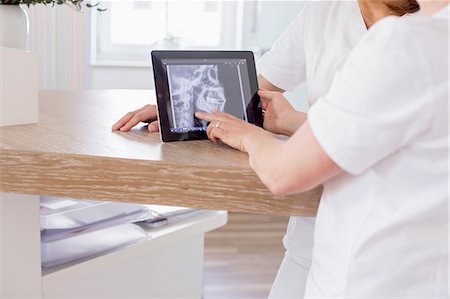 Dentists looking at digital tablet with x-ray image of jaw on screen Photographie de stock - Premium Libres de Droits, Code: 649-08548361