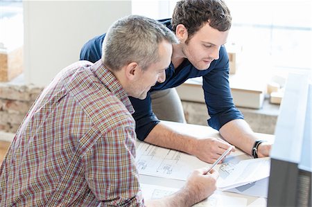 simsearch:649-08548438,k - High angle view of men in office discussing paperwork Photographie de stock - Premium Libres de Droits, Code: 649-08548478