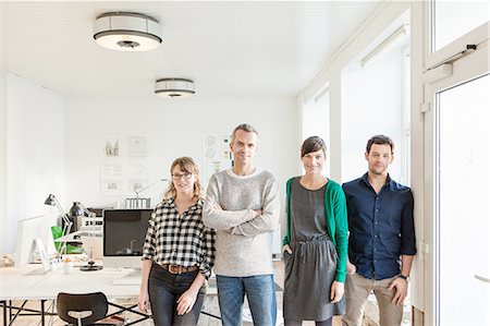 simsearch:649-07279688,k - Colleagues in office side by side looking at camera smiling Stock Photo - Premium Royalty-Free, Code: 649-08548484