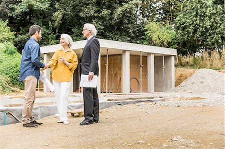 redevelopment - Couple on construction site shaking hands with architect smiling Stock Photo - Premium Royalty-Free, Code: 649-08548534