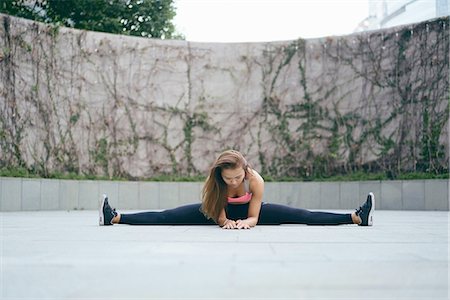 simsearch:649-09209612,k - Young woman outdoor exercising doing the splits Foto de stock - Royalty Free Premium, Número: 649-08548628