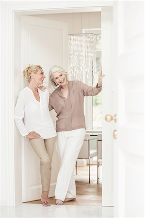 standing style images - Mother and daughter standing together at home, laughing Stock Photo - Premium Royalty-Free, Code: 649-08548684