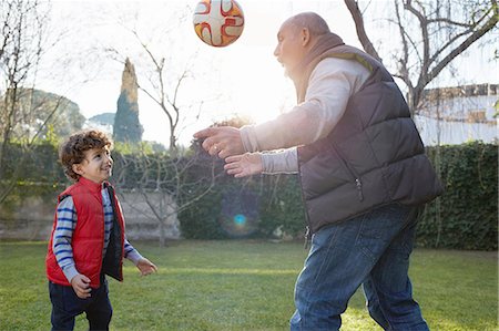 Grandfather and grandson playing with football smiling Stock Photo - Premium Royalty-Free, Code: 649-08548944