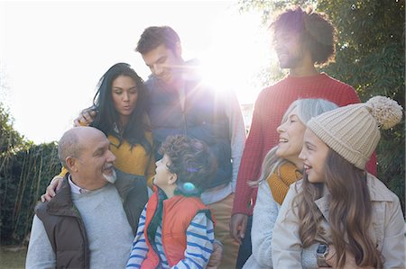 Multi generation family huddled together chatting and smiling Stock Photo - Premium Royalty-Free, Code: 649-08548950