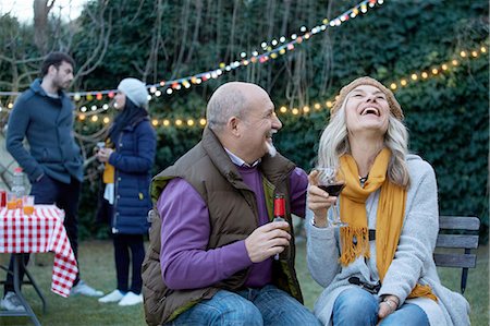 socializing - Mature couple at garden party throwing head back laughing Foto de stock - Sin royalties Premium, Código: 649-08548981