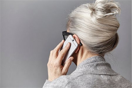 foto in studio - Grey haired woman using smartphone to make telephone call Fotografie stock - Premium Royalty-Free, Codice: 649-08549358