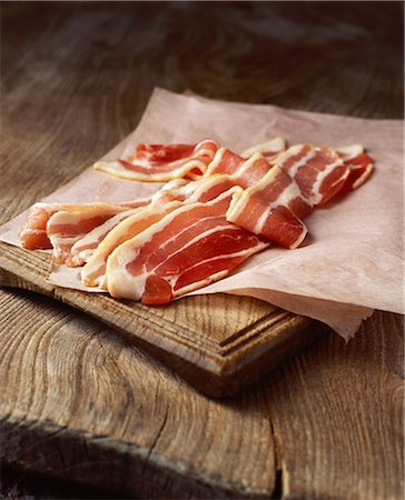 processed meats - Rashers of raw streaky bacon on baking paper Stock Photo - Premium Royalty-Free, Code: 649-08549366