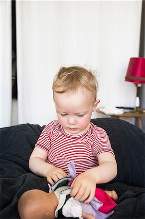 Baby girl playing with baby doll Stock Photo - Premium Royalty-Free, Code: 649-08543158