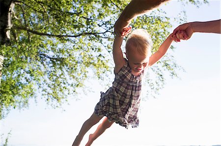 Father swinging baby girl in air, outdoors, low angle view Photographie de stock - Premium Libres de Droits, Code: 649-08543162