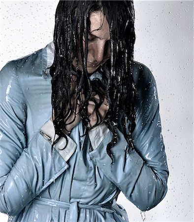 rainshower - Woman wearing raincoat drenched in water looking down Stock Photo - Premium Royalty-Free, Code: 649-08543279