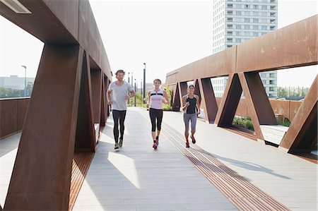 simsearch:649-08702370,k - Male and female runners running on urban footbridge Stock Photo - Premium Royalty-Free, Code: 649-08543322