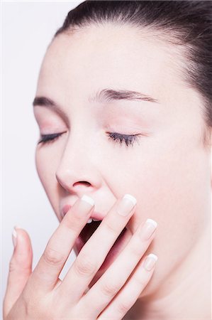 Head shot of young woman yawning Stock Photo - Premium Royalty-Free, Code: 649-08543362