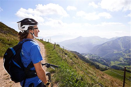simsearch:6128-08728334,k - Cyclist wearing cycling helmet looking at view of mountains Stock Photo - Premium Royalty-Free, Code: 649-08543482