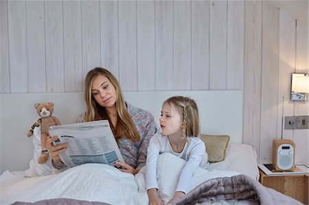 simsearch:649-08543567,k - Mother reading newspaper beside daughter in bed Foto de stock - Royalty Free Premium, Número: 649-08543574