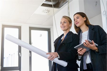 exam success - Businesswomen with blueprint inspecting in new office Stock Photo - Premium Royalty-Free, Code: 649-08543694