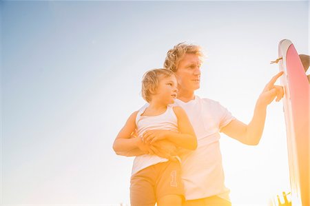 points - Low angle view of father holding son looking at surfboard Photographie de stock - Premium Libres de Droits, Code: 649-08543793