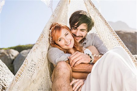 simsearch:649-08543868,k - Couple sitting in lace teepee looking at camera smiling Stock Photo - Premium Royalty-Free, Code: 649-08543889