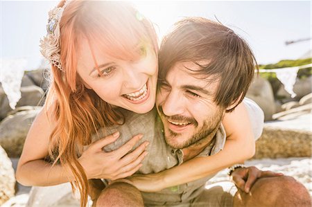 simsearch:649-08543866,k - Woman behind man arms around shoulders smiling Stock Photo - Premium Royalty-Free, Code: 649-08543893