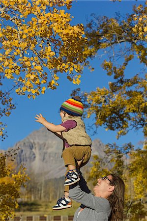 simsearch:614-07444036,k - Mother holding up toddler amongst autumn trees Photographie de stock - Premium Libres de Droits, Code: 649-08565232