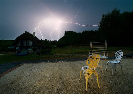 strike - Lighting in night sky behind house Fotografie stock - Premium Royalty-Free, Codice: 649-08565414